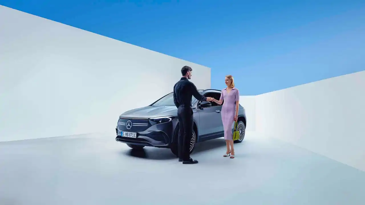 Mécanicien Mercedes-Benz rendant à une femme les clefs de son SUV Mercedes