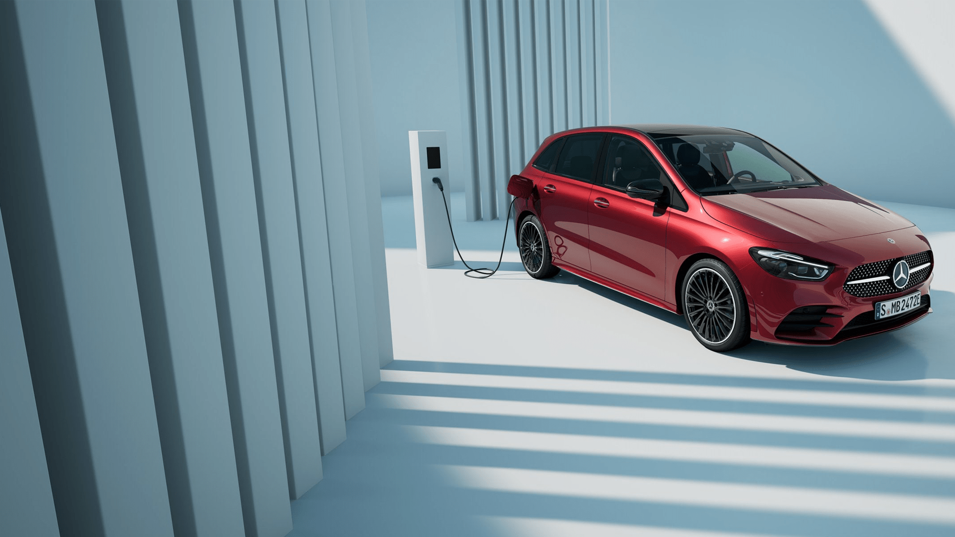 Classe B hybride rechargeable en finition rouge branchée sur une borne de recharge électrique