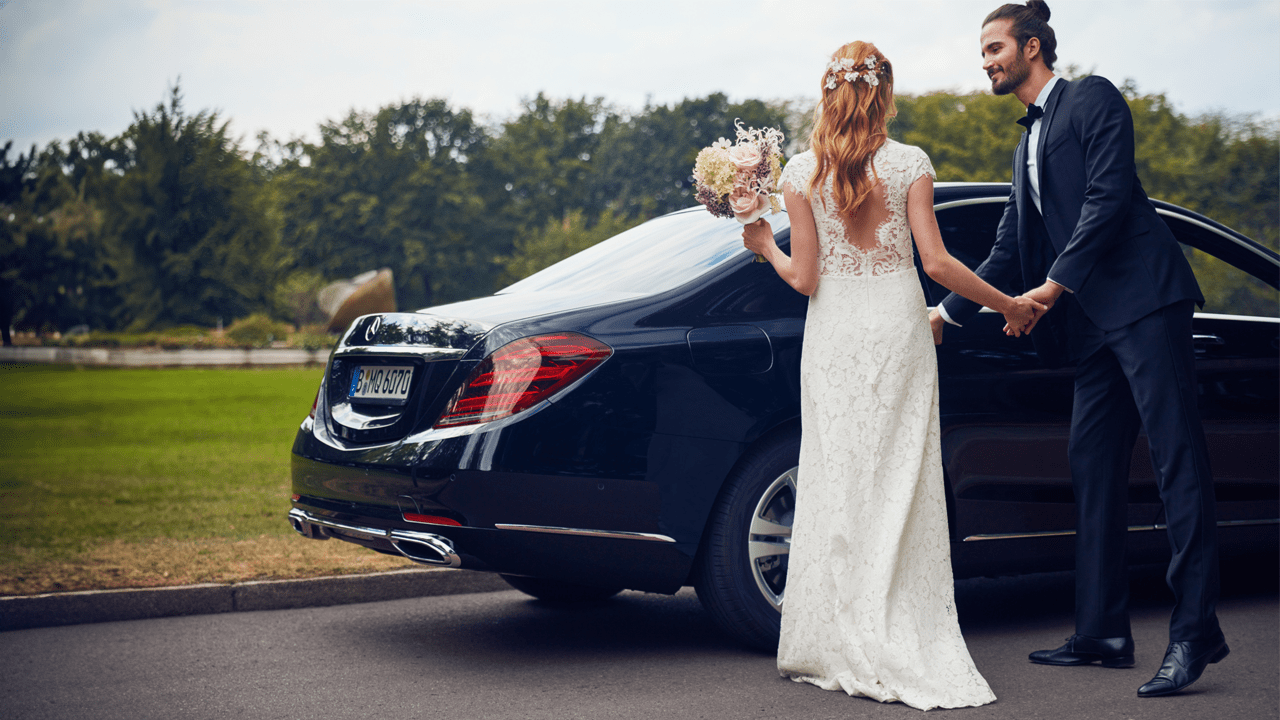 Mariés entrant dans leur Mercedes