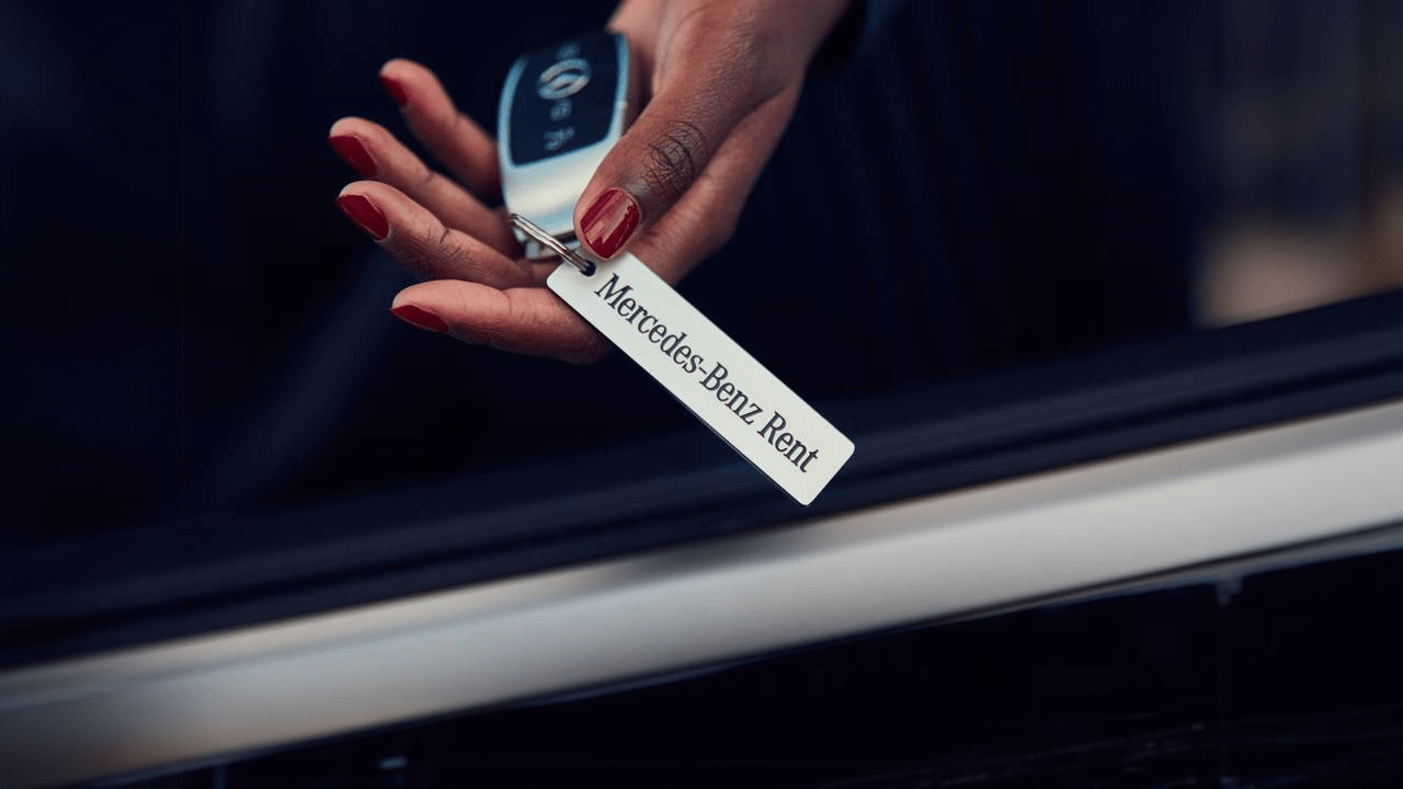 Main d'une femme tenant les clefs de sa voiture de location Mercedes-Benz