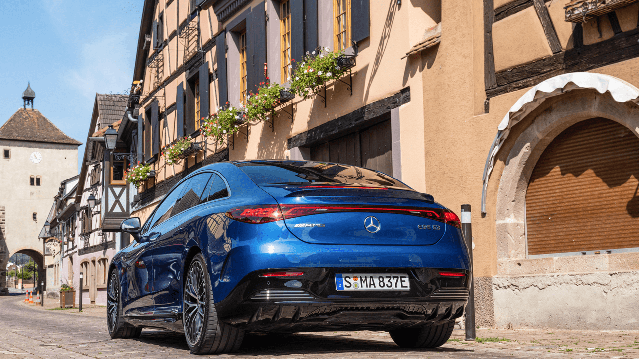 Mercedes EQE circulant en centre ville au milieu des maisons à colombages