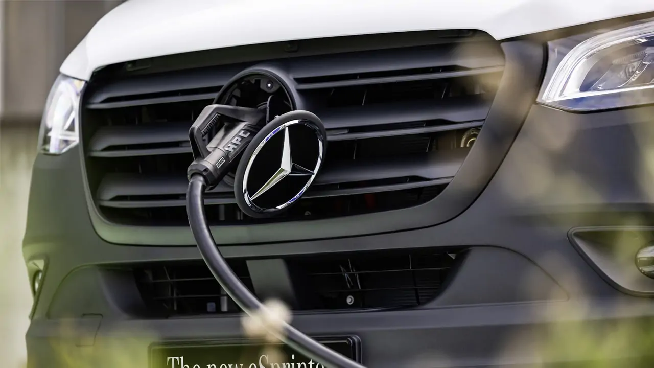 eSprinter branché à une borne de recharge grâce à sa prise de charge située derrière le logo Mercedes