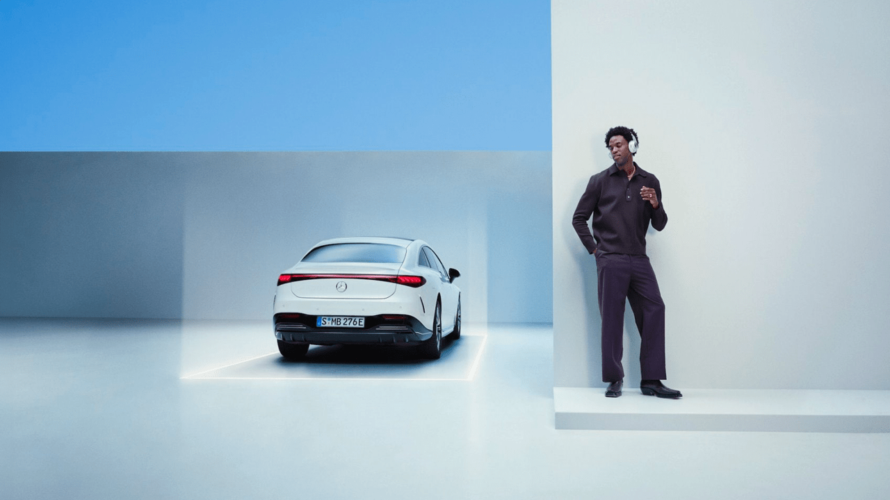 Homme écoutant de la musique à côté de son Mercedes EQE