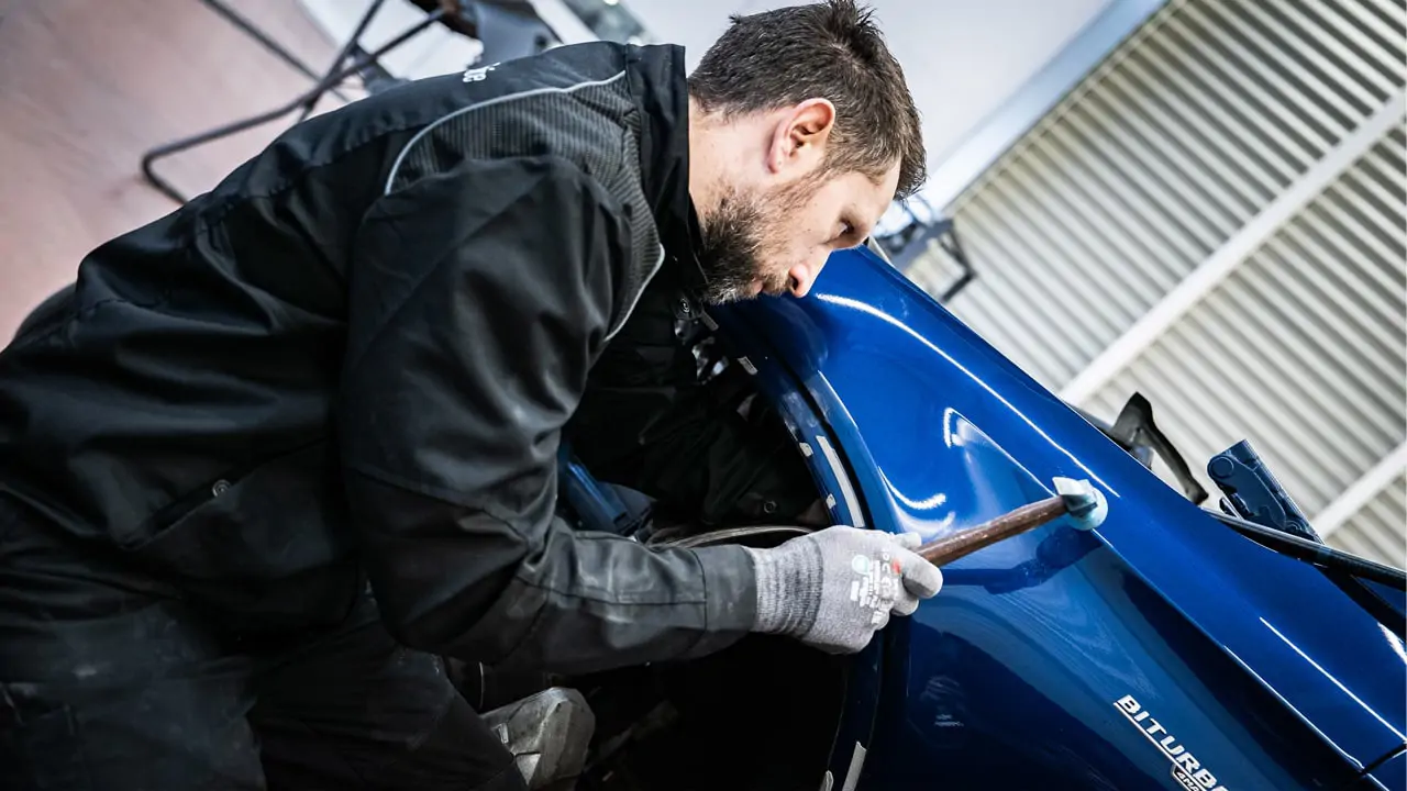 Carrossier Kroely intervenant sur une voiture